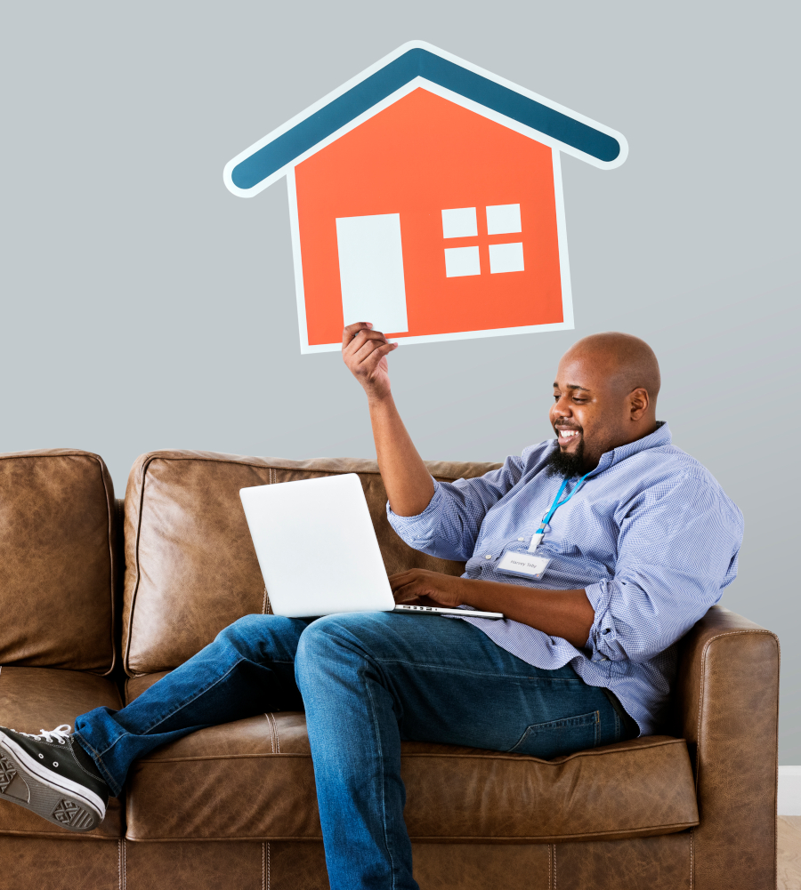 Black man working on laptop Man showing house icon on couch